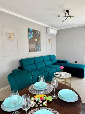 a living room with a blue couch and a table at Sea Sun in Burgas City
