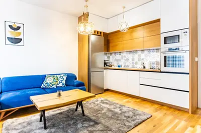 a living room with a blue couch and a table at Arena MALL Galleria Securities Parking 3 in Burgas City
