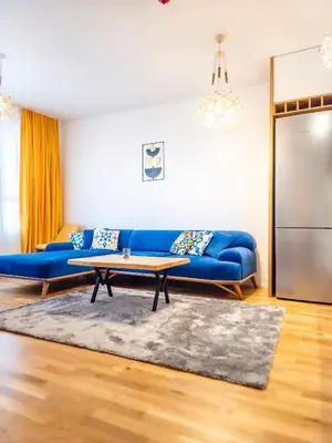 a living room with a blue couch and a table at Arena MALL Galleria Securities Parking 3 in Burgas City
