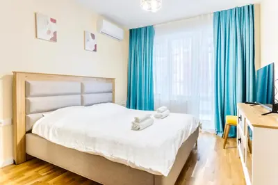 a bedroom with a bed with blue curtains at Arena MALL Galleria Securities Parking 3 in Burgas City