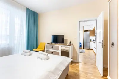 a white bedroom with a bed and a television at Arena MALL Galleria Securities Parking 3 in Burgas City