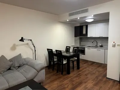 a living room with a couch and a table and a kitchen at Platinum apartment in Bŭnzareto