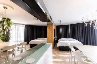 a hotel room with two beds and tables and chairs at Arena MALL Galleria & Parking 4 in Burgas City