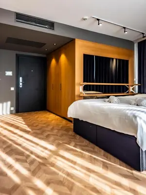 a bedroom with two beds and a wooden floor at Arena MALL Galleria & Parking 4 in Burgas City
