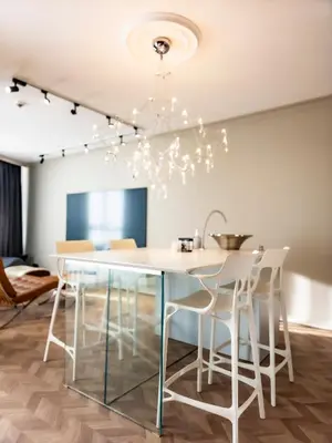 a dining room with a glass table and white chairs at Arena MALL Galleria & Parking 4 in Burgas City