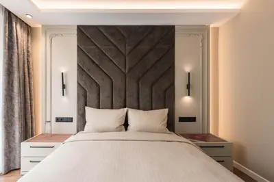 a bedroom with a large bed with a large headboard at City Center Luxury Apartments in Varna City
