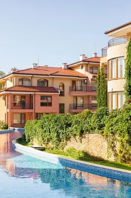 a building next to a river next to a building at Panorama Dreams - Prestige Apartments in Sveti Vlas