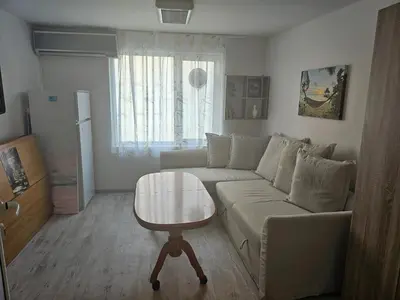 a living room with a couch and a table at Малко студио в центъра на град Бургас II in Burgas City