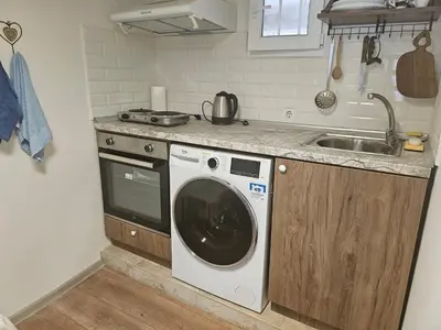 a kitchen with a washing machine and a sink at Малко студио в центъра на град Бургас II in Burgas City