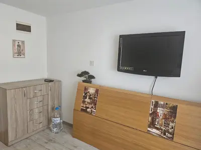 a living room with a flat screen tv on a wall at Малко студио в центъра на град Бургас II in Burgas City