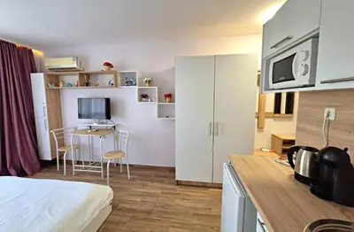 a room with a bed and a kitchen with a table at Studio for rent Cascadas in Sunny Beach