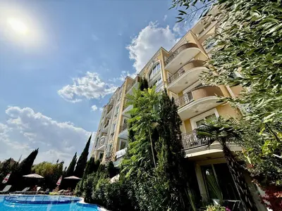 a building with a swimming pool in front of it at Messembria Palace - Menada Apartments in Sunny Beach