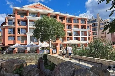two people walking on a bridge in front of a building at Carina Beach - Private apartment - BSR - 3 in Sunny Beach