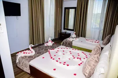 a room with two beds with red roses on them at Къща за гости Силвия in Shkorpilovtsi
