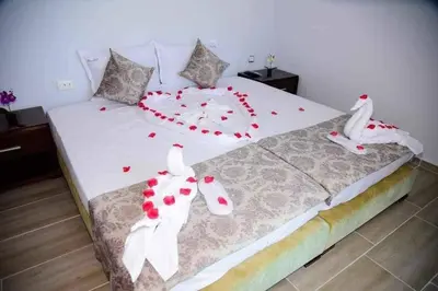 a large bed with red and white decorations on it at Къща за гости Силвия in Shkorpilovtsi