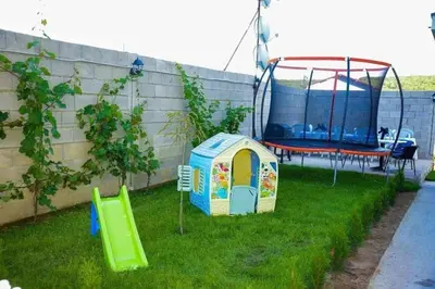 a play yard with a play house and a swing at Къща за гости Силвия in Shkorpilovtsi