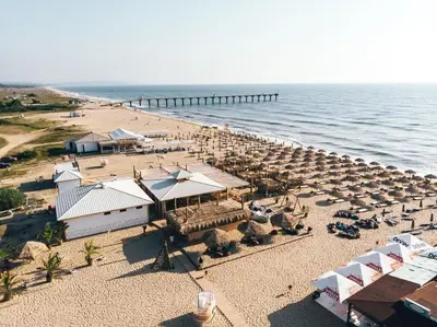 an aerial view of a beach with umbrellas and the ocean at Морски бриз in Shkorpilovtsi