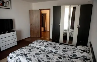 a bedroom with a bed and a dresser and a television at Морски бриз in Shkorpilovtsi