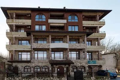 a tall brick building with windows and a balcony at Морски бриз in Shkorpilovtsi