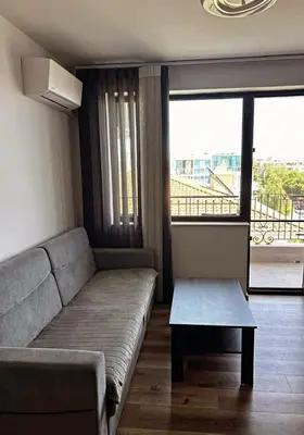 a living room with a couch and a table at The better apartment in Burgas City