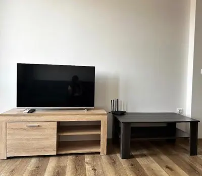 a flat screen tv sitting on top of a wooden entertainment center at The better apartment in Burgas City