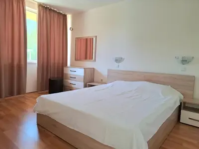 a bedroom with a white bed and a window at Sineva Apartments in Ravda