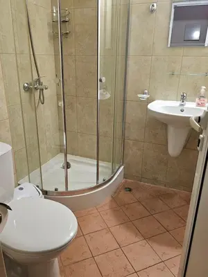 a bathroom with a shower and a toilet and a sink at Sineva Apartments in Ravda