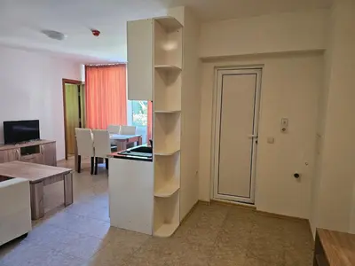 a living room with a white refrigerator and a table at Sineva Apartments in Ravda
