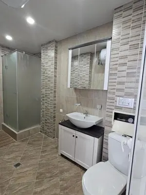 a bathroom with a toilet and a sink and a shower at Sineva Apartments in Ravda