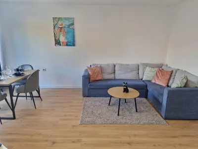 a living room with a blue couch and a table at Sea apartment- Gurko in Burgas City