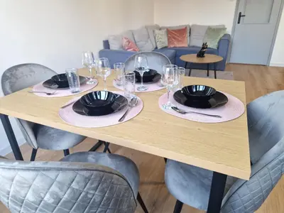 a wooden table with plates and wine glasses on it at Sea apartment- Gurko in Burgas City