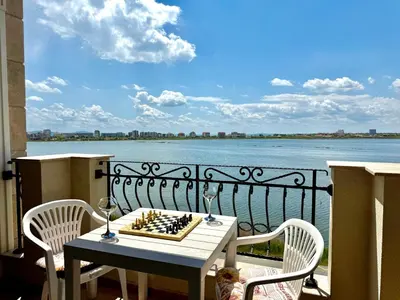 a table and chairs on a balcony with a view of the water at Cosher Gardenia Palace Apt 6 Free Parking in Pomorie