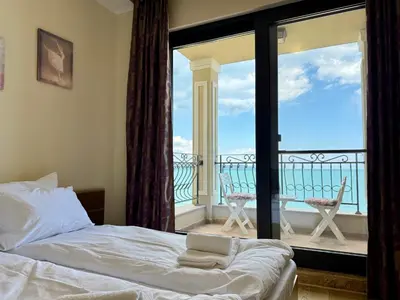 a bedroom with a bed and a view of a balcony at Cosher Gardenia Palace Apt 6 Free Parking in Pomorie