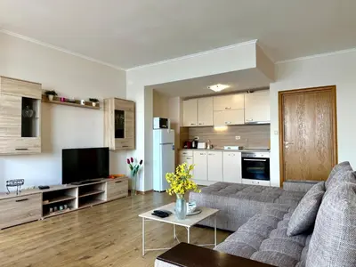 a living room with a couch and a kitchen at Cosher - Gardenia Palace Apt 9 Free Parking in Pomorie