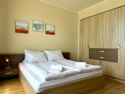 a bedroom with a large bed with white sheets at Cosher - Gardenia Palace Apt 7 Free Parking in Pomorie