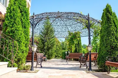 a group of benches in a garden with a gazebo at Cosher - Gardenia Palace Apt 7 Free Parking in Pomorie