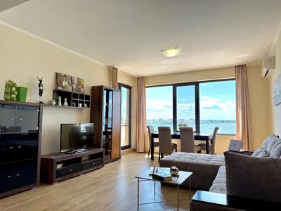 a living room with a couch and a television and a table at Cosher - Gardenia Palace Apt 11 Free Parking in Pomorie