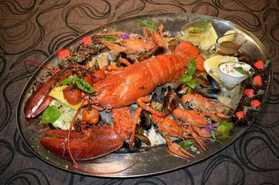 a plate of lobster and other foods on a table at Cosher - Gardenia Palace Apt 11 Free Parking in Pomorie