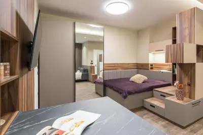 a small bedroom with a bed and a mirror at City Center Luxury Studio in Varna City