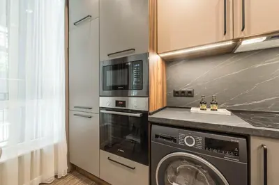 a kitchen with a washing machine and a microwave at City Center Luxury Studio in Varna City