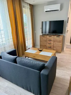 a living room with a blue couch and a tv at Work and Relax Studio in Green Life Beach Resort in Sozopol
