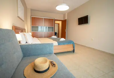 a hotel room with a bed and a hat on a couch at Stylish Holiday Apartments in Karolina in Sunny Beach