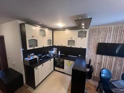 a kitchen with white cabinets and a black counter top at Нощувки Град Бяла Terrazza sul mare in Byala
