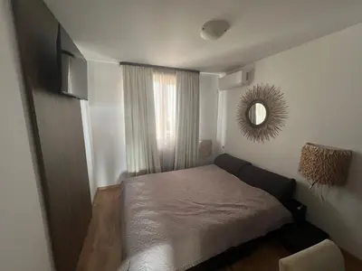 a small bedroom with a bed and a mirror at Нощувки Град Бяла Terrazza sul mare in Byala