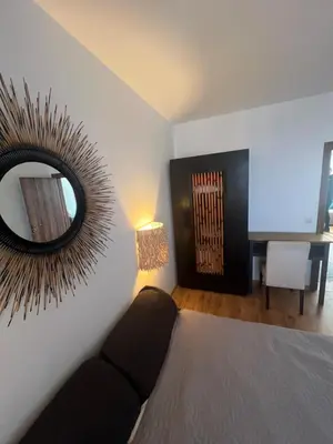 a room with a mirror and a couch and a table at Нощувки Град Бяла Terrazza sul mare in Byala