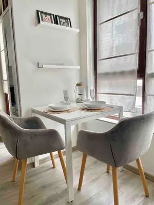 a dining room table with two chairs and a white table at Deluxe studio beach Lazur in Burgas City