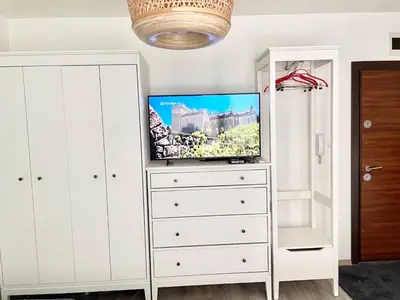 a white dresser with a tv on top of it at Deluxe studio beach Lazur in Burgas City