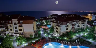 a view of a city at night with the moon at Lavish, Poolside 2 Bed Apt at Garden of Eden in Sveti Vlas