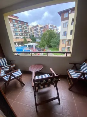 a balcony with two chairs and a large window at Lavish, Poolside 2 Bed Apt at Garden of Eden in Sveti Vlas