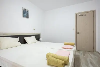 a bedroom with a large white bed with a yellow chair at Marea in Pomorie